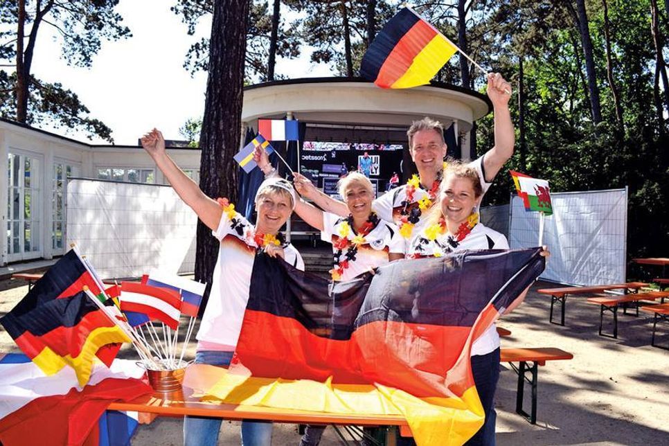 Das Veranstaltungs-Team der TSNT GmbH, Martina Block (links), Jessica Gotthilf und Janina Schütze (rechts) sowie Caterer Frank Berger („Ars Vivendi“) sind bereit für das Public Viewing vor der Musikmuschel neben der Trinkkurhalle in Timmendorfer Strand. (Foto: René Kleinschmidt)