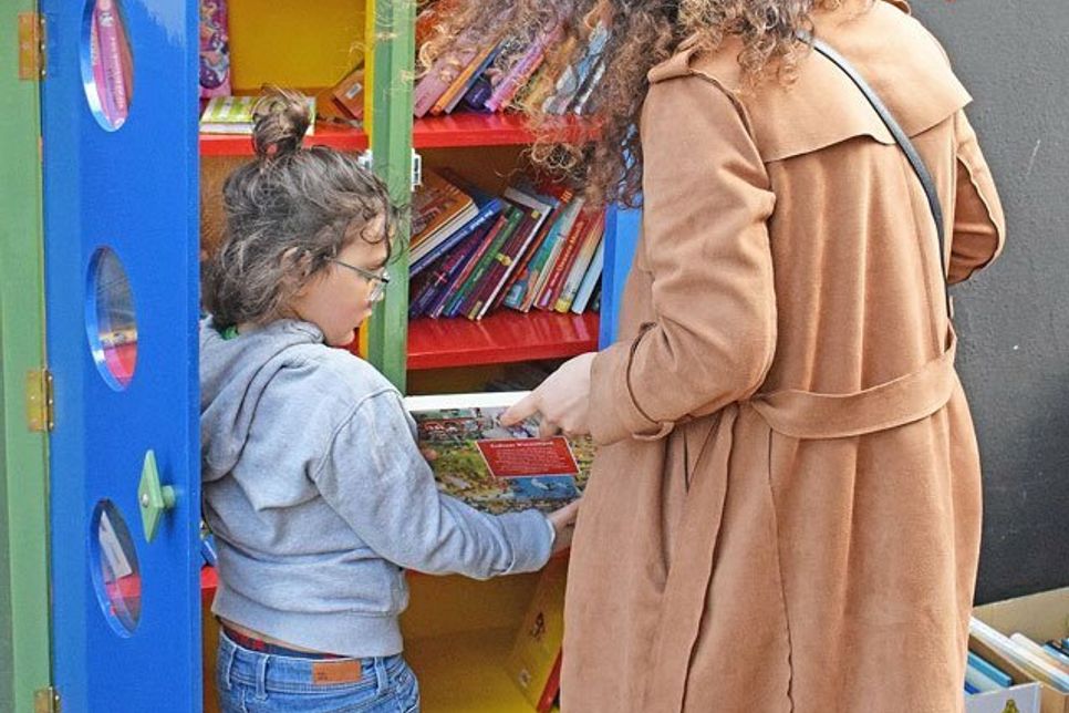 Der Tauschschrank ist bereits stark nachgefragt: Kinder entdecken mit ihren Eltern das tolle Angebot