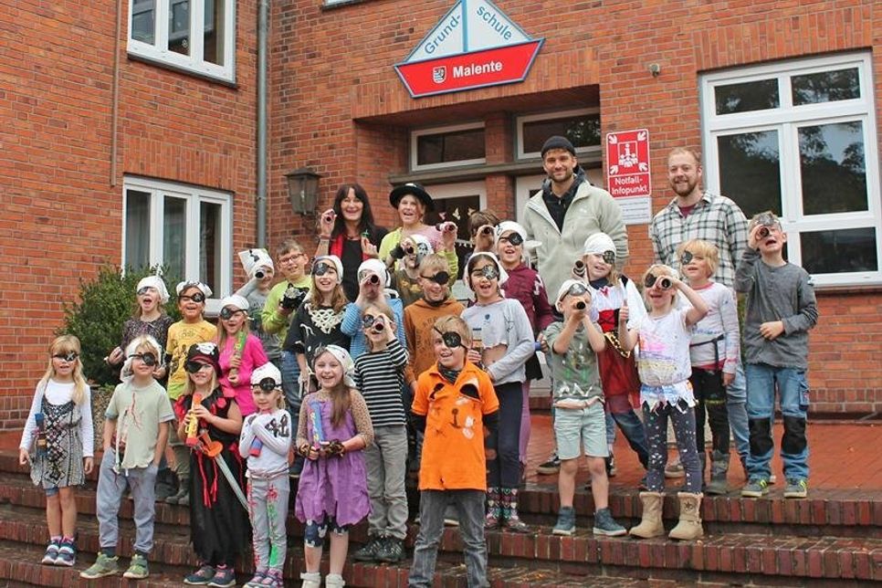Die Piratenfahne hängt aus dem Fenster über Gabi Dummer (obere Reihe links), Nils Dummer (oben Zweiter von rechts) und Jannic Strehse (oben rechts) und den kleinen Seeräubern.