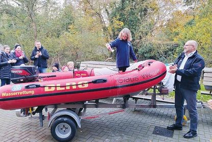 Taufpatin Luisa bei der Bootstaufe am DLRG-Heim in Niendorf/Ostsee, Vorsitzender Olaf Techen applaudiert.