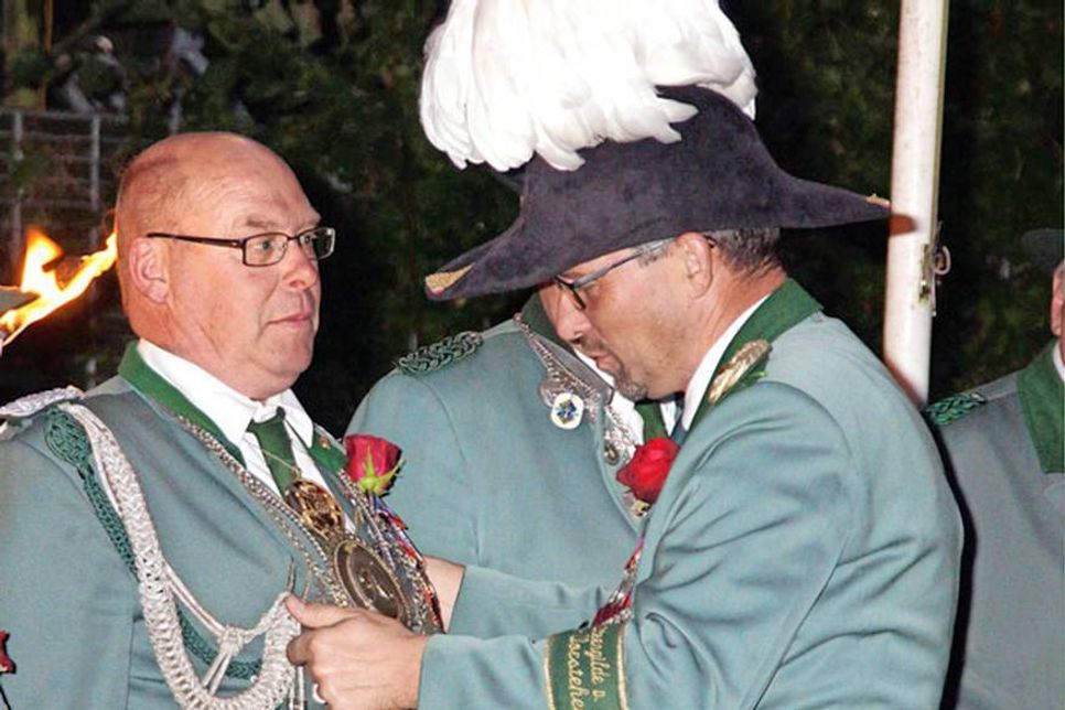 Der neue große König bekommt die Insignien seiner Herrschaft verliehen: Der wortführende Vorsteher der Eutiner Schützengilde Heiko Godow legt der neuen Majestät Jürgen Kehr die Königskette um.