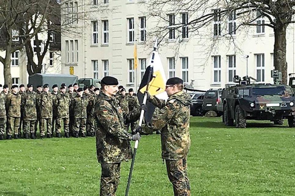 Symbolisch für das Kommando übergibt Hauptmann David Cacic (li.) den Wimpel zurück an Oberstleutnant Tobias Aust.