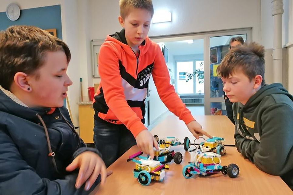 Ove Bornschein, Frieder Seidel und Lucas Berg nehmen die Roboter als Jury unter die Lupe.