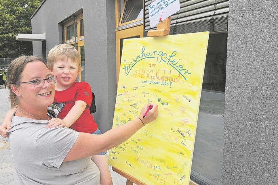 Sie waren dabei: Cora Koch und Sohn Linus verewigen sich auf der Leinwand zur Eröffnungsfeier. „Die Kinder haben jetzt mehr Freiheiten und einen sehr schön gestalteten Außenbereich“, freut sich die Mutter über den Neubau.