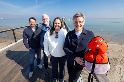 André Rosinski, Vorstand der Tourismus-Agentur Lübecker Bucht (TALB), Seebrückenschwimmen-Schirmfrau Sandra Völker, Martin Lenz (Agentur PALM-SPORTS) und TALB-Veranstaltungsleiter Alexander Will (v.re.) auf der Seebrücke in Scharbeutz, dem Zielort des Seebrückenschwimmen-Finales.