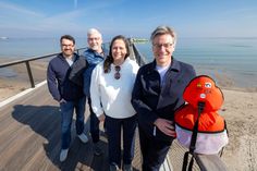 André Rosinski, Vorstand der Tourismus-Agentur Lübecker Bucht (TALB), Seebrückenschwimmen-Schirmfrau Sandra Völker, Martin Lenz (Agentur PALM-SPORTS) und TALB-Veranstaltungsleiter Alexander Will (v.re.) auf der Seebrücke in Scharbeutz, dem Zielort des Seebrückenschwimmen-Finales.