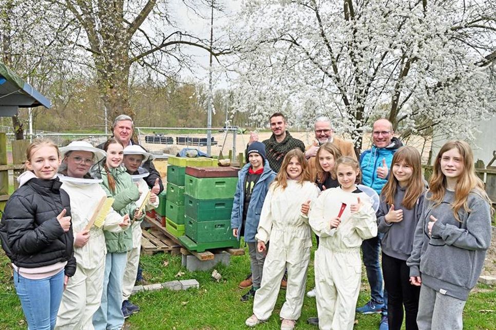 Die Schüler der Bienen AG der Plöner Gemeinschaftsschule präsentierten sich anlässlich der Spendenübergabe mit ihren Bienenstöcken und den Förderen dieses Projekts. Angeleitet werden die Fünft- und Sechstklässler von Michael Wehrend vom Imker Verein Plön (v. l.), betreut von Naturwissenschafts-Lehrer Sascha Michaelis, finanziell unterstützt von Dirk Carstens (Carstens Optic in Plön) und vernetzt durch Deutsch- und Sportlehrer Jörn Hinrichsen, der ebenfalls das Thema Nachhaltigkeit an der Schule vermittelt.