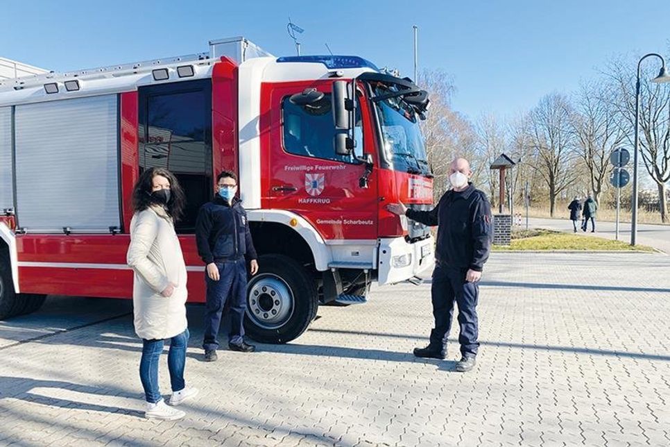Bürgermeisterin Bettina Schäfer und Gemeindewehrführer Patrick Bönig bekommen vom hauptamtlichen Gerätewart Svend-Ole Reimers das System am Fahrzeug erklärt.