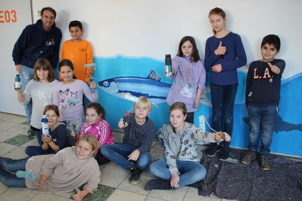 Graffitikünstler Jonas Wömpner (lks.) von „Hochkreativ“ mit einigen an dem Projekt beteiligten Schülern.
