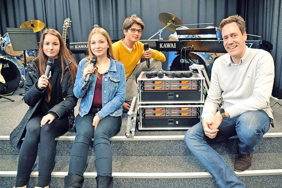 Acht neue Mikrofone für die Schulband: Mia (13, links), Emily (14) und Noah (15) freuen sich mit Musiklehrer Jan-Taken de Vries über die neue Mikrofonanlage. (Foto: René Kleinschmidt)