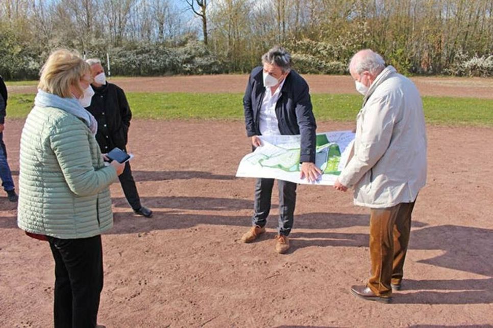 SPD-Bundestagsabgeordnete Bettina Hagedorn lässt sich von Bürgermeister Andreas Zimmermann (parteilos) den Plan für das Neubaugebiet und die Neugestaltung der Sportplätze zeigen