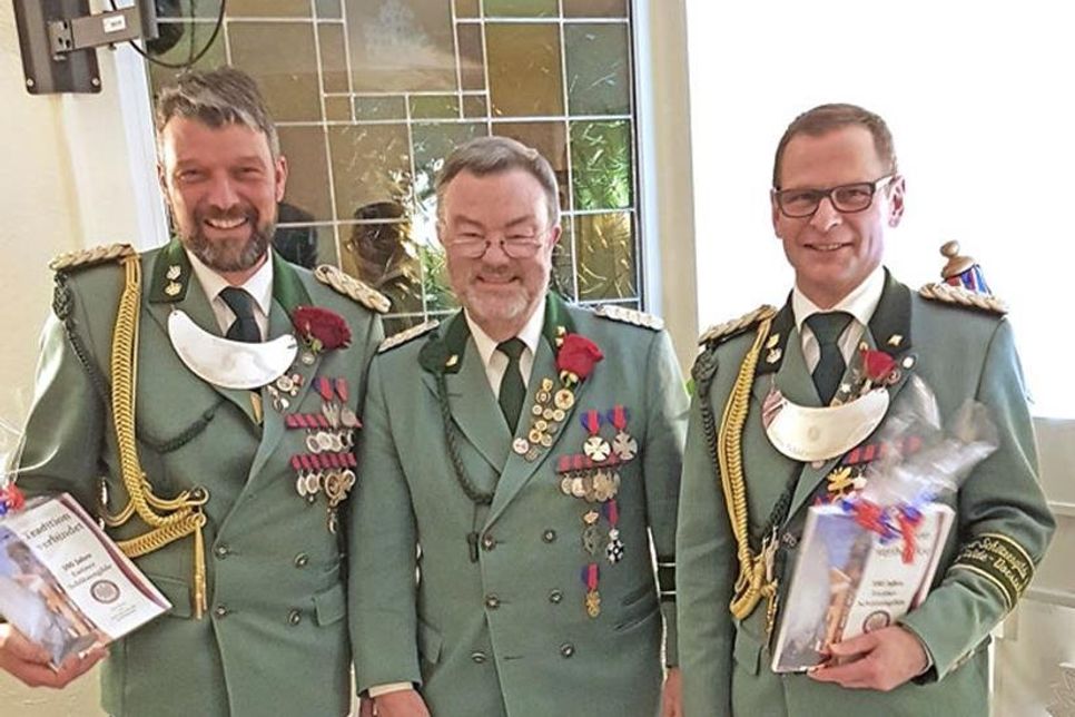 Ehrenoffizier Klaus Schröder überreichte den beiden Vorstehern Heiko Godow und André Meyer veredelte Sonderdrucke der Gildechronik.