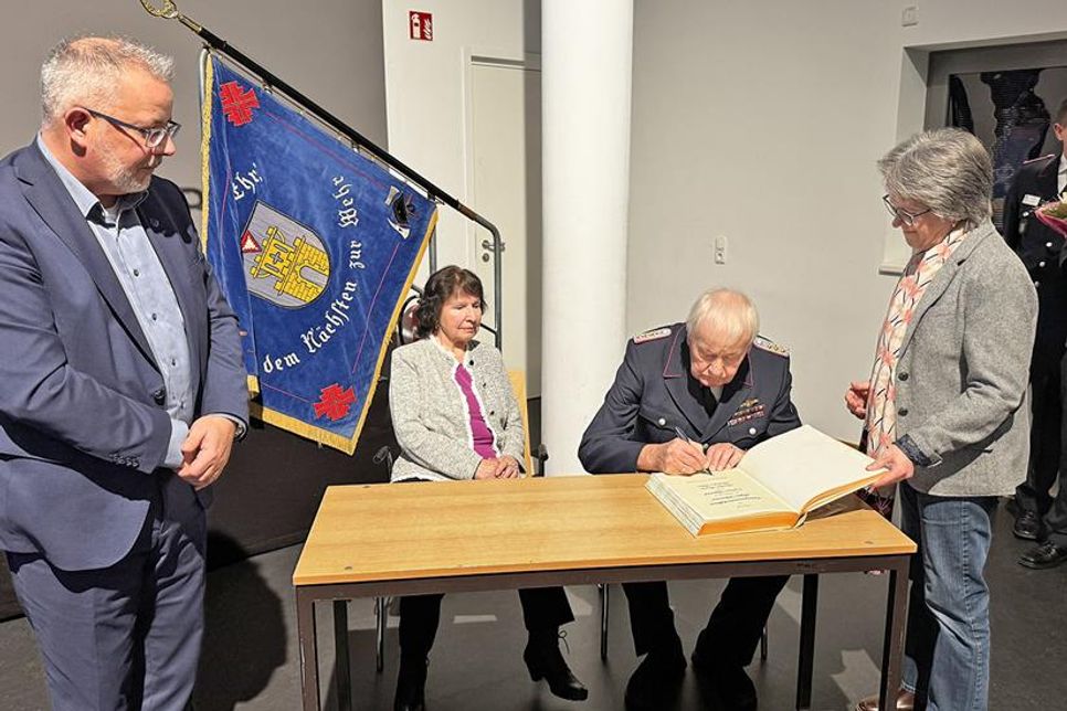Ehrengemeindewehrführer Jürgen Klärmann trägt sich im Beisein von seiner Ehefrau Ilona, Bürgervorsteherin Susanne Knees und Bürgermeister Jörg Saba in das goldene Buch der Stadt ein.