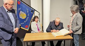 Ehrengemeindewehrführer Jürgen Klärmann trägt sich im Beisein von seiner Ehefrau Ilona, Bürgervorsteherin Susanne Knees und Bürgermeister Jörg Saba in das goldene Buch der Stadt ein.