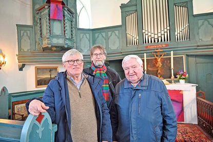 Wolfgang Habenicht-Voss, Pastor Ulrich Gradert und Wolfgang Regel (v. l.) vom Förderverein Johanniskirche kündigen den runden Vereinsgeburtstag am 19. Juli an und freuen sich auf neue Kontakte und noch mehr Austausch bei der Kirchensprechstunde am 7. Mai.