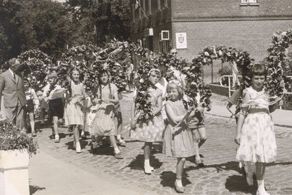 Festumzug beim Schul-Kinderfest vor rund 70 Jahren: Kinder ziehen mit Blumenkränzen durch das Dorf - damals noch über das Kopfsteinpflaster der heutigen B 501.