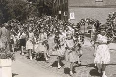 Festumzug beim Schul-Kinderfest vor rund 70 Jahren: Kinder ziehen mit Blumenkränzen durch das Dorf - damals noch über das Kopfsteinpflaster der heutigen B 501.