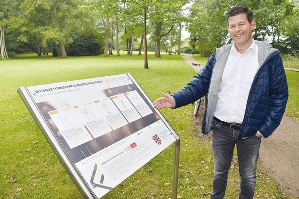 Thomas Albertin zeigt auf die Tafel, auf denen alle Fitnessgeräte erklärt werden. Er war für die Gemeindeverwaltung maßgeblich an der Umsetzung des Fitness-Parcours beteiligt.