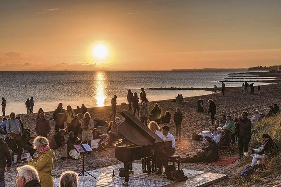 Neben dem Trompetenecho, das von einem Trompetenspieler am Strand und einem weiteren auf einem Fischerboot inszeniert wird, sorgt Pianist Clemens Wiencke am Konzertflügel für die passende Musik zum Sonnenaufgang am Meer. (Fotos: TSNT/Torsten Vollbrecht)