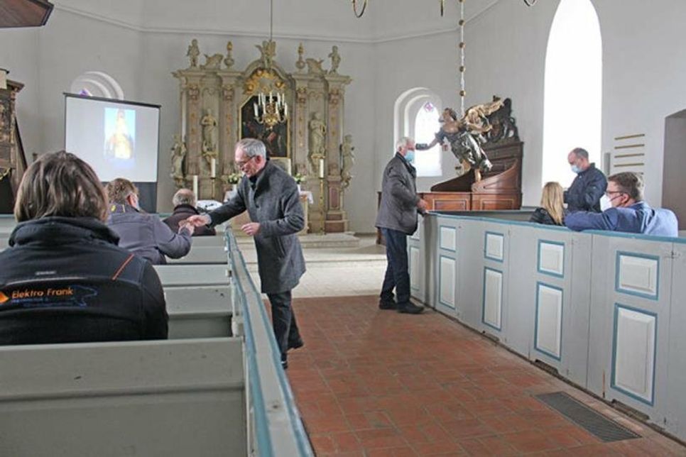 Pastor Dr. Arnd Heling und stellvertretender Kirchengemeinderatsvorsitzender Rudi Hoffmann bedanken sich mit einer Ritzzeichnung des Taufengels bei allen Beteiligten
