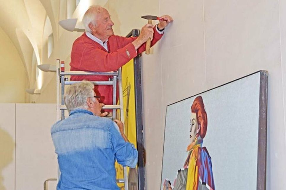 Das Bild hängt schief: Ein großformatiges Werk von Peter Nagel erhält seinen Platz im Plöner Kulturforum.