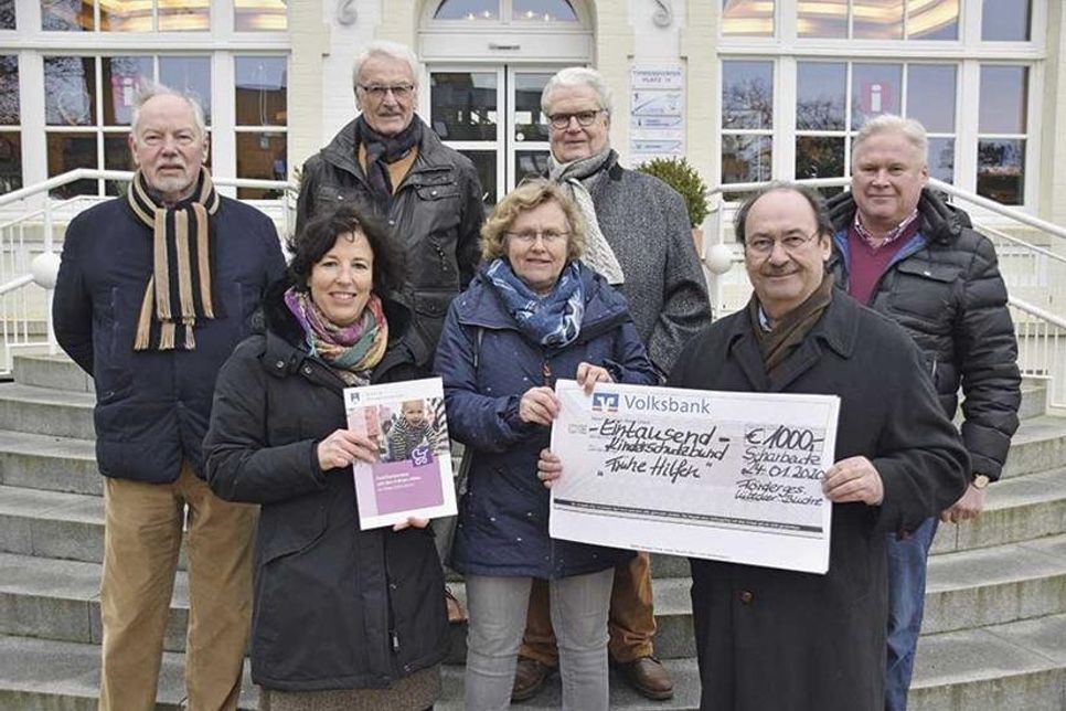 Scheckübergabe vor dem Alten Rathaus: Volker Simon, Peter Anders und Karl-Friedrich Lihra vom Shantychor Timmendorfer Strand (hi.v.li.) übergeben mit Karl-Heinz Bremeyer und Bernd Vetter vom Lions Lübecker Bucht den Spendenscheck an Katja Kirschall (vo. li.) und Mechtild Piechulla.