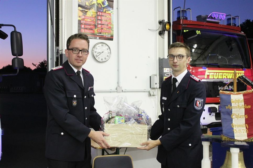 Pascal Holm von der Jugendfeuerwehr (re.) überreichte einen Präsentkorb an Jacob Revenstorf und dankte für sein Engagement.