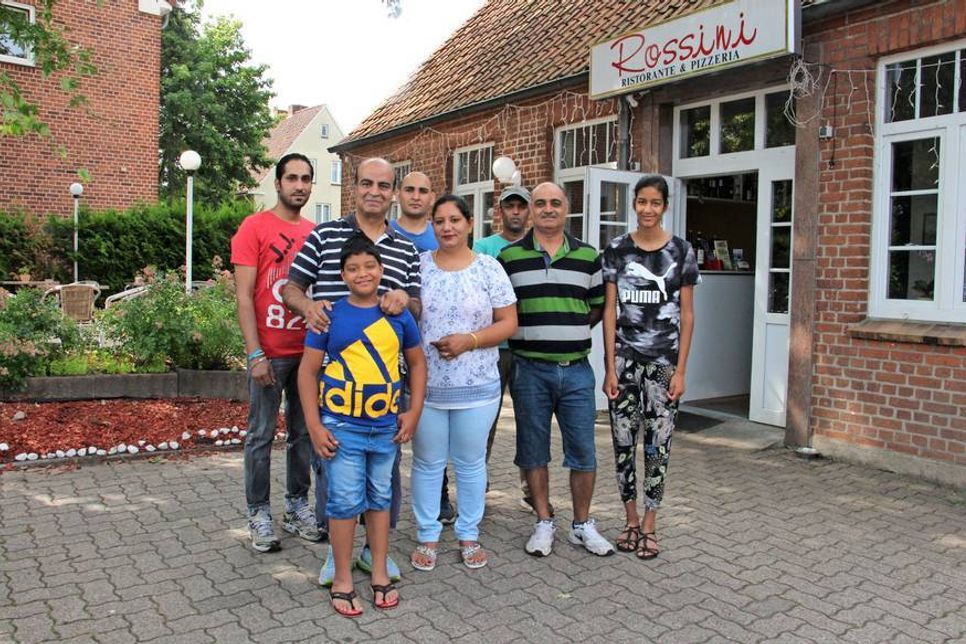 Rajesh Kohli (2. v. lks.) mit seiner Familie und Mitarbeitern vor dem charmanten Restaurant mit Terrasse.