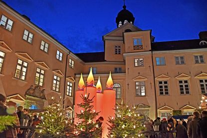Zum 25. Mal verwandelt sich der Schlosshof in ein weihnachtliches Budendorf, in dessen Zentrum alle Jahre wieder die roten Riesenkerzen stehen.