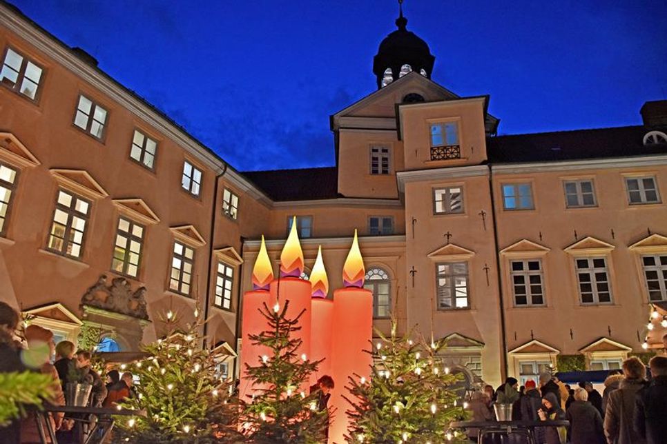 Zum 25. Mal verwandelt sich der Schlosshof in ein weihnachtliches Budendorf, in dessen Zentrum alle Jahre wieder die roten Riesenkerzen stehen.