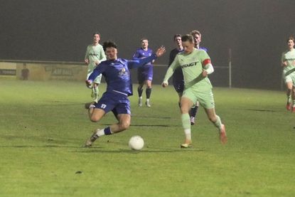 Paul Kuszak grätscht in letzter Sekunde den Ball vor dem gegnerischen Kapitän ab.