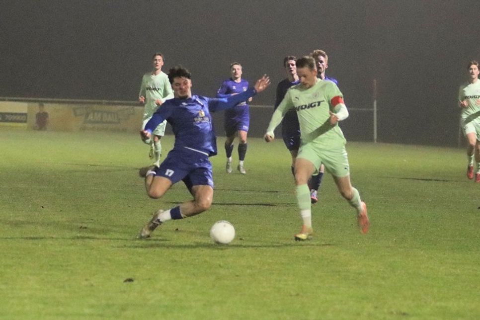 Paul Kuszak grätscht in letzter Sekunde den Ball vor dem gegnerischen Kapitän ab.