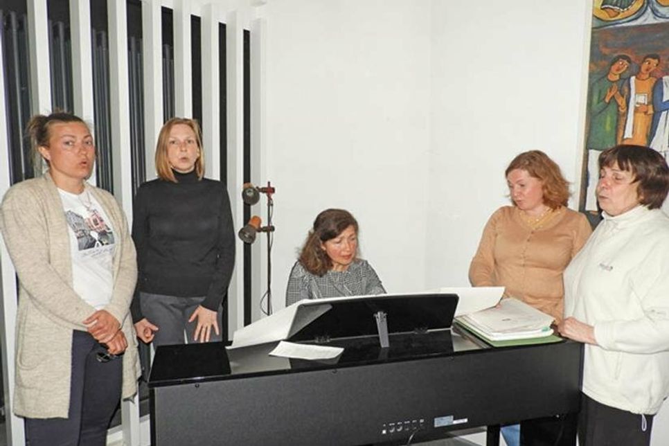 Für ihre Hymne stehen die Frauen auf, Swetlana Andresen begleitet sie.