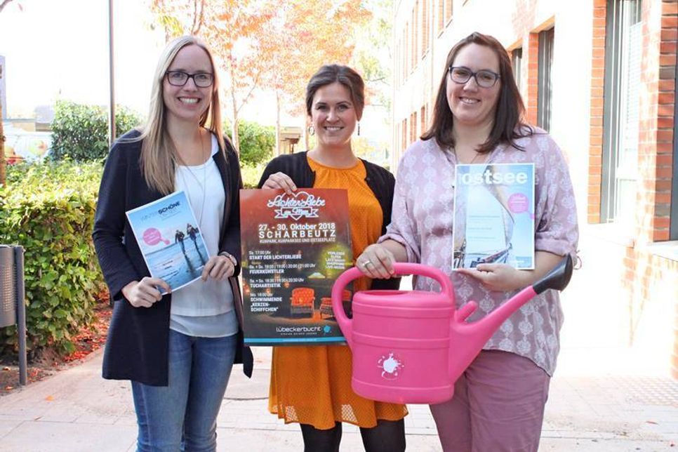 V. lks.: Julia Prange (Ostsee-Holstein-Tourismus), Tabea Braun (Tourismus-Agentur Lübecker Bucht) und Claudia Drögsler (Ostsee-Holstein-Tourismus) mit der beleuchteten Gieskanne, dem Symbol für geöffnete Geschäfte beim Late-Night-Shopping.