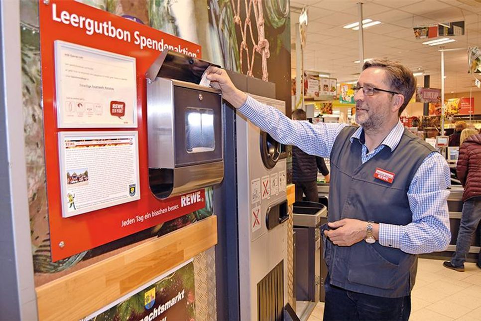 REWE-Chef Reinhard Bödicker geht mit gutem Beispiel voran und spendet den ersten Pfandbon nach der Leerung. (Foto: Stefan Setje-Eilers)