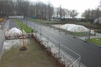 Blick auf das Schulgelände mit Volleyballfeld und Weitsprunganlage.