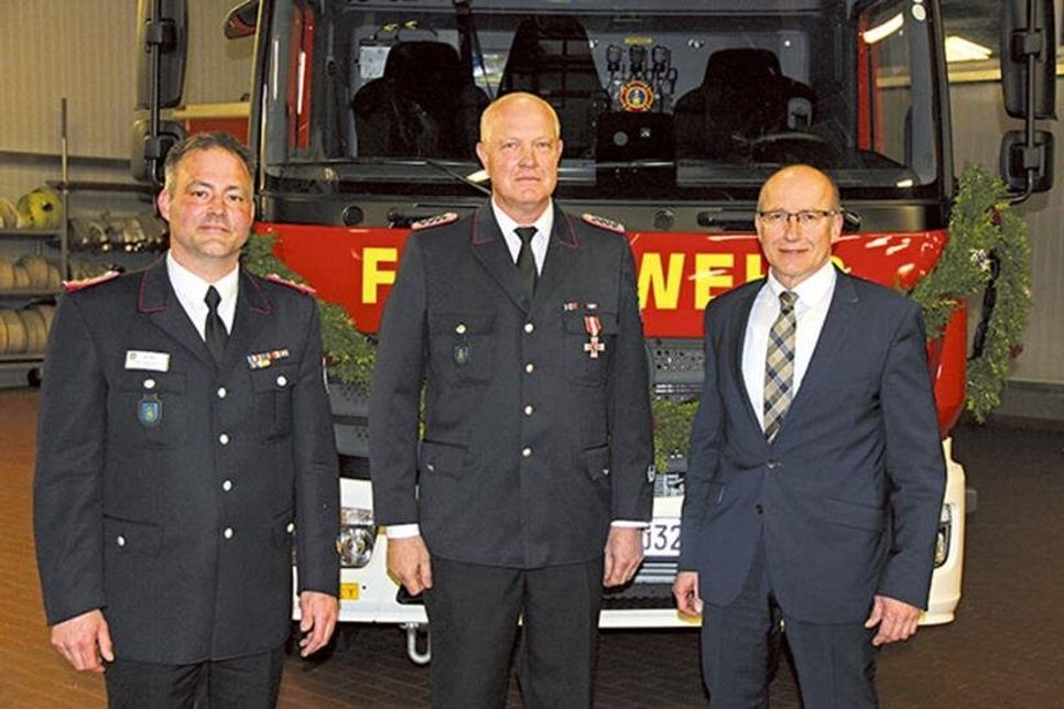 Björn Mougin und Bürgermeister Martin Voigt gratulieren Karsten Prokoph zum Brandschutz-Ehrenzeichen in Gold (am Bande).