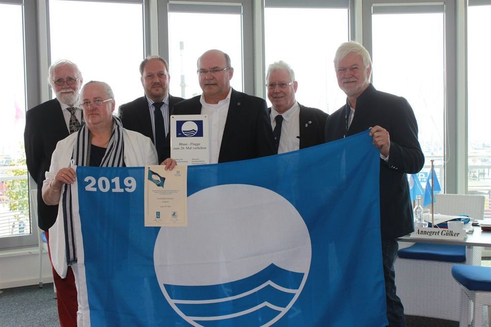 Für den Yachthafen Grömitz wurde die Blaue Flagge an Lars Widder (Mi.), Betriebsleiter TSG, übergeben.
