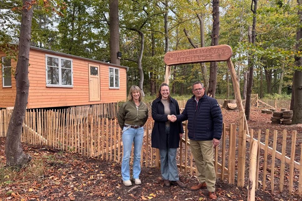 Bürgermeister Sebastian Rieke gratuliert Josi Bente im Beisein von Gemeinde-Mitarbeiterin Frau Helling zur Eröffnung des Naturkindergartens Klostersee.