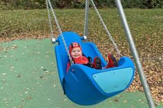 Die kleine Tomke freut sich sichtlich über die neue Babyschaukel auf Kellenhusens neuem Inklusionsspielplatz.