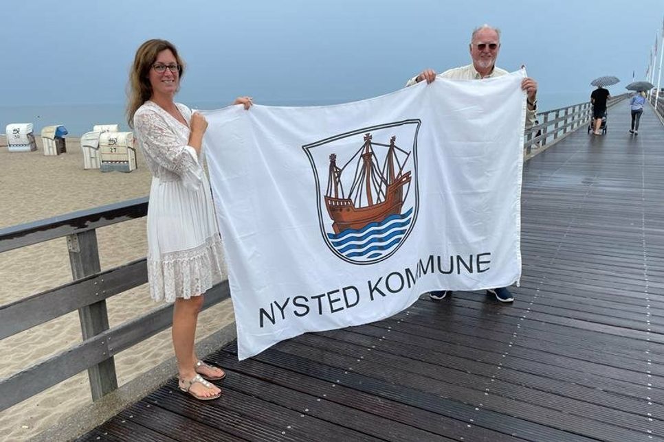 Jürgen Möller vom Heimat- und Kulturverein Dahme übergab die Nysted Flagge an Bürgermeisterin Stefanie Friedrich-Suhr.