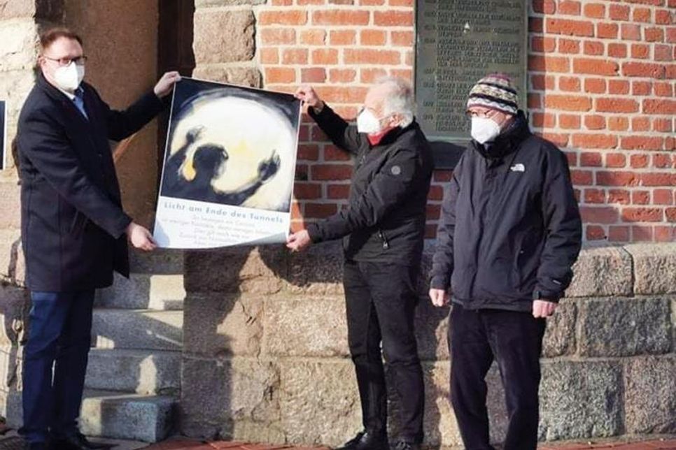 Der Hamburger Künstler Jörn Wessel unterstützt den Appell von Bürgermeister Jan Lindenau (links) mit dem Plakat „Licht am Ende des Tunnels“.