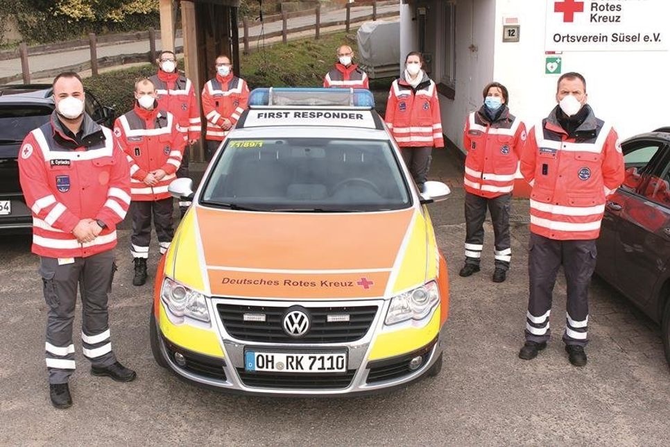 Bereitschaftsleiter Robin Cyriacks (lks.) mit Kolleginnen und Kollegen der First Responder Einheit vor dem neuen Fahrzeug der Einheit.