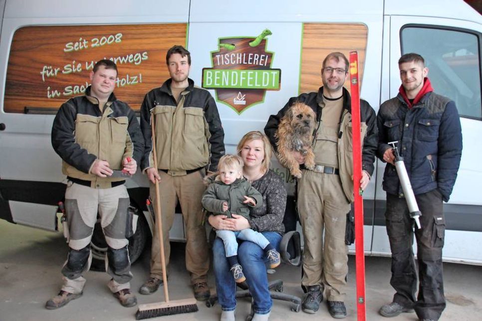 Das Tischlerteam mit Marcel Riemke (Geselle), Daniel Schmidt (Auszubildender), Ehefrau Christiana Orlowski-Bendfeldt, Nachwuchstischler Nils, Tischlermeister Dirk Bendfeldt mit Hund Connor und Jan Hendrik Malzkeit (v. lks.).