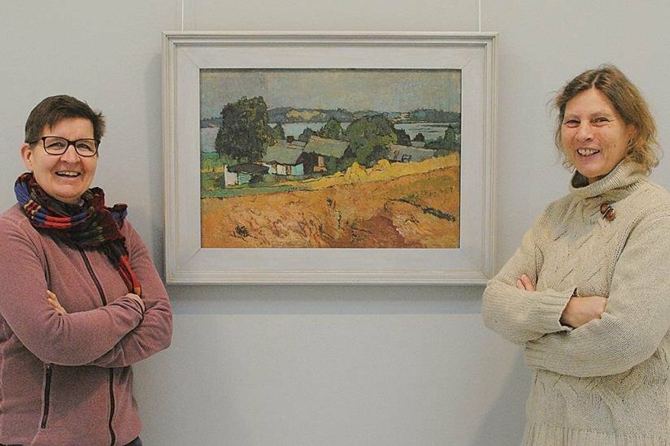 Sigrid Paulsen-McCord (l.), Sabine Behrens und ein typisches Gemälde von Otto Niemeyer-Holstein, das er 1955 gemalt hatte. Es zeigt ein „Dorf am Schmollensee“.