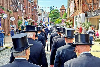 Mit schwarzem Anzug und hohem Hut marschieren die Gildebrüder wieder durch Preetz.