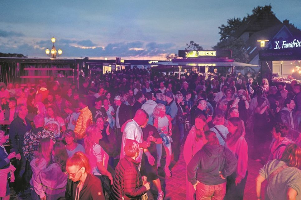 Am Abend verwandelt sich das Binnenwasserfest in eine stimmungsvolle Party mit Livemusik und ausgelassener Feierlaune.