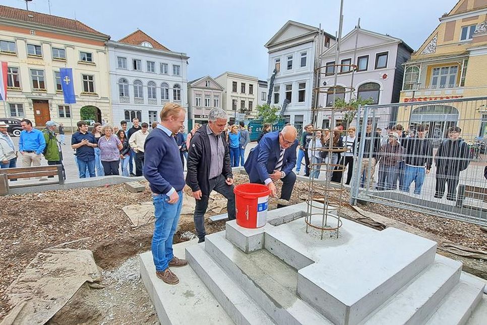 Sven-Hendrik Nittritz, Sven Radestock und Andreas Zabel befüllten die Zeitkapsel und mauerten sie dann im Sockel des Ehrenmals auf dem Marktplatz ein.