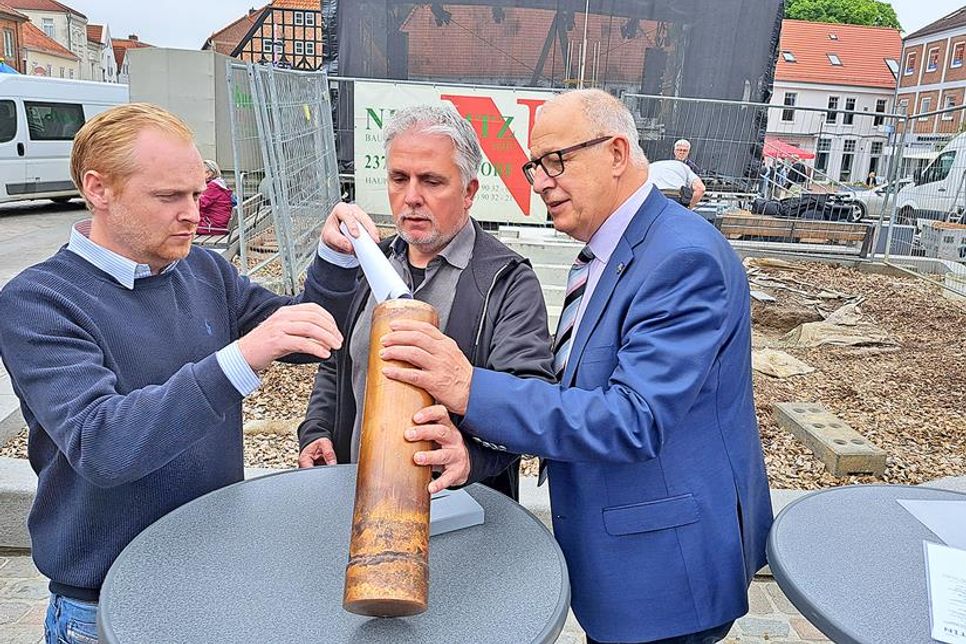 Sven-Hendrik Nittritz, Sven Radestock und Andreas Zabel befüllten die Zeitkapsel und mauerten sie dann im Sockel des Ehrenmals auf dem Marktplatz ein.
