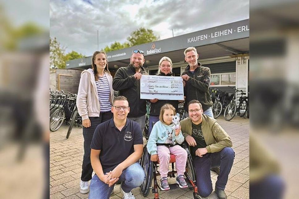 Die 5-jährige Hannah aus Ahrensbök freut sich mit ihren Eltern und Kevin Pirsig (l. Aktion Traumfänger) über die tolle Unterstützung durch den Fahrradverleih „Tobis Rad“ aus Scharbeutz (hintere Reihe von rechts).